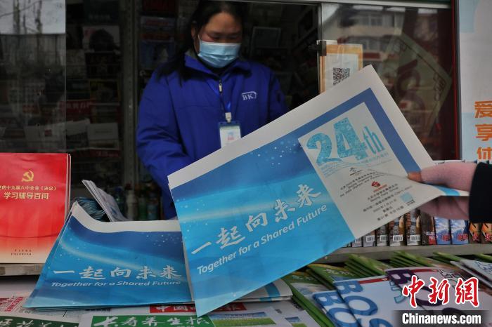 图为读者在报刊亭购买会刊。北京冬奥组委供图