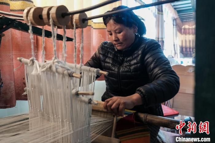 图为玉珍在织邦典，她三天可织一幅，售价为500元。江飞波 摄
