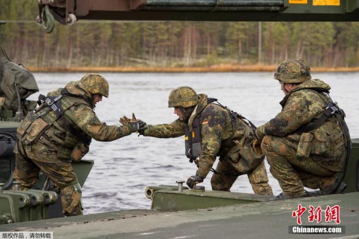 资料图：北大西洋公约组织在挪威及其周边地区举行联合军事演习。图为德军工程营士兵在河道上架设浮桥。