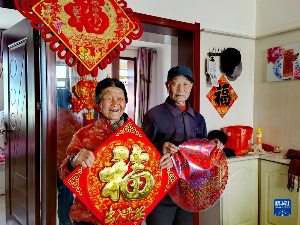 刘福有(右)和老伴在山西省忻州市岢岚县城移民搬迁小区的家中(2021年12月22日摄,手机照片)。新华社发 article_img