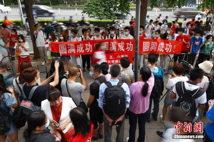 资料图:2021年6月7日,北京人大附中考点外,送考同学为考生拉横幅加油。当日,中国2021年高考正式拉开大幕,1078万名考生赶赴考场。 <a target='_blank' href='/'>中新社</a>记者 富田 摄 article_img