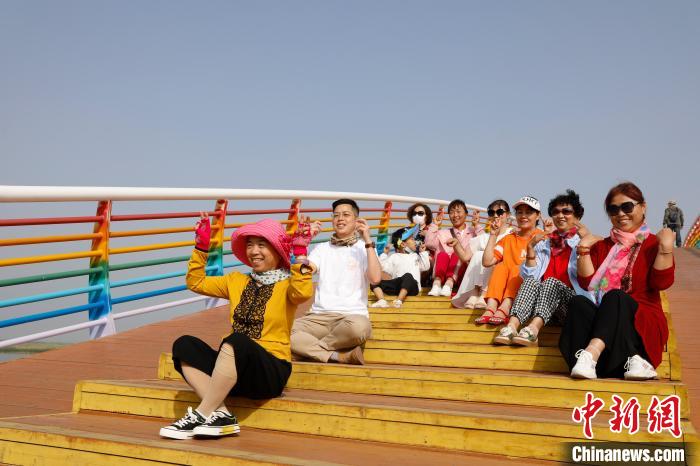 台青(左二)在沙湖景区七彩鹊桥上与市民合照。杨迪 摄 article_img