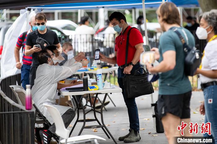 资料图:当地时间7月26日,美国纽约曼哈顿一处猴痘疫苗接种点,工作人员为民众验证预约信息。 <a target='_blank' href='/'>中新社</a>记者 廖攀 摄 article_img