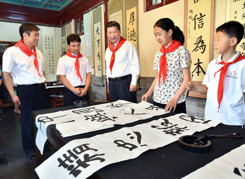2014年5月30日上午，中共中央总书记、国家主席、中央军委主席习近平来到北京市海淀区民族小学，参加庆祝“六一”国际儿童节活动。这是习近平观看学生书写的毛笔字。新华社记者 李涛 摄