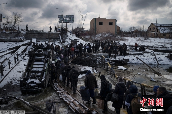 资料图：乌克兰基辅郊区，当地民众撤离伊尔平时，穿过一条在废墟上临时搭建的道路。
