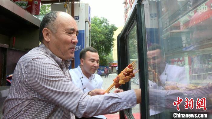 阿布力克木·麦麦提(左)在制作烤肉。高嘉琪 摄 article_img