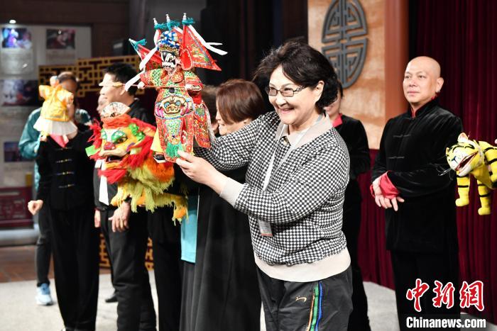 海外华文媒体代表陈薇(前)体验布袋木偶操作。吕明 摄 article_img