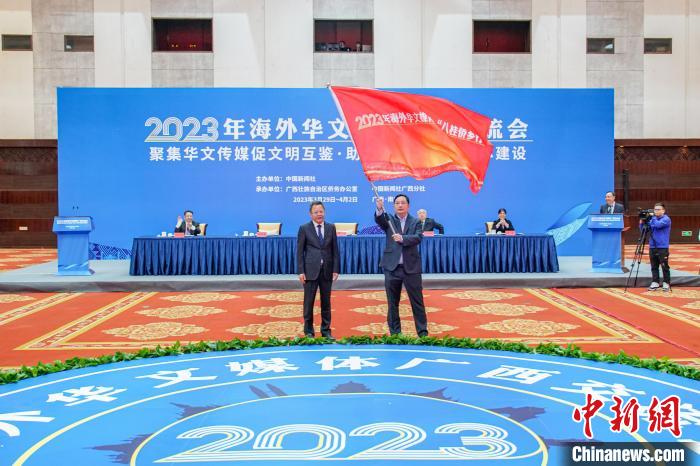 图为王心富(左)向与会华文媒体代表陆宝华(右)授旗。陈冠言 摄 article_img