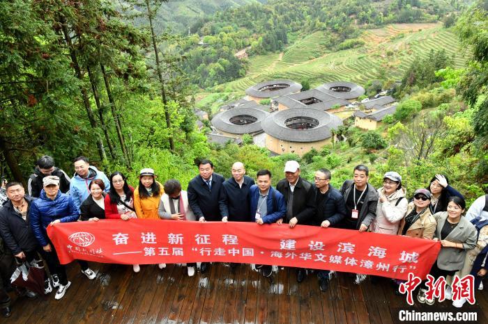 海外华文媒体代表在南靖田螺坑土楼群前合影留念。吕明 摄 article_img