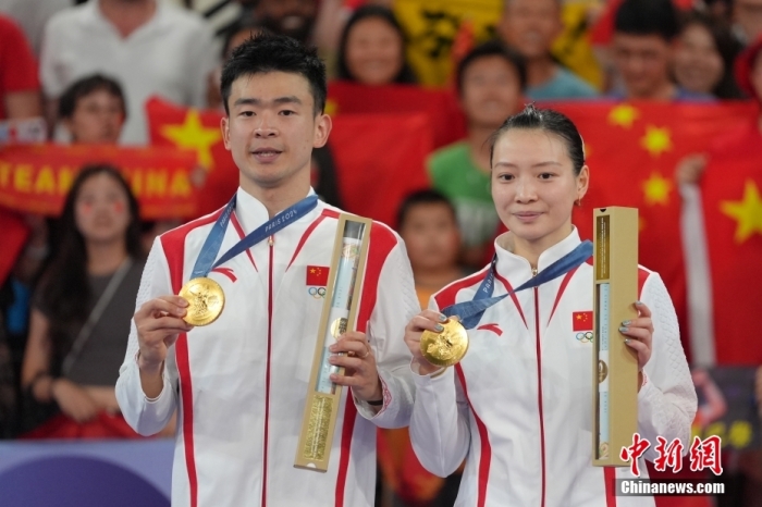 当地时间8月2日,在巴黎奥运会羽毛球混合双打决赛中,中国组合郑思维/黄雅琼以2-0胜韩国组合金元昊/郑娜银,获得金牌。图为颁奖仪式上,郑思维/黄雅琼(右)展示金牌。<a target='_blank' href='/'>中新社</a>记者 赵文宇 摄 article_img