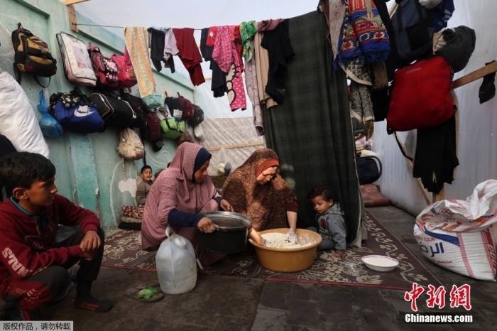 图为当地时间2023年12月27日,流离失所的巴勒斯坦人在加沙地带南部拉法的一个帐篷内居住。 article_img